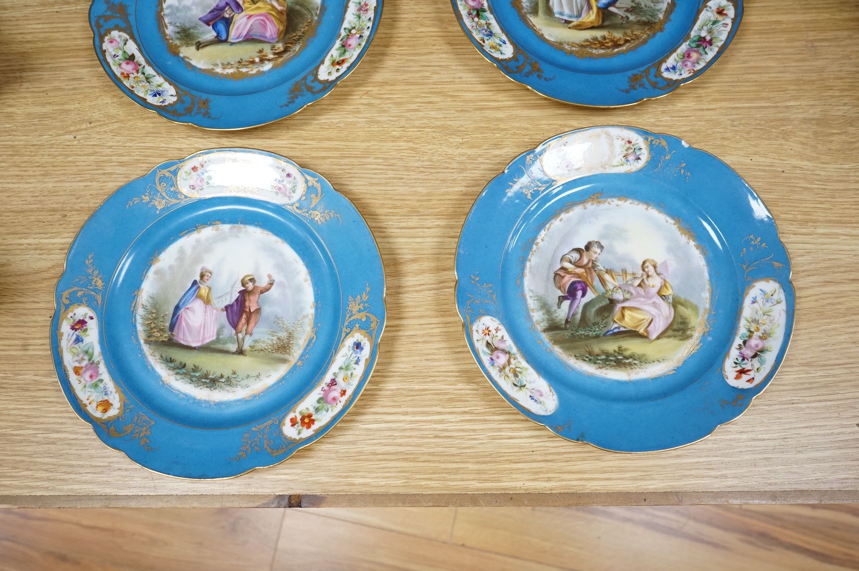 A set of eight 19th century Sevres style bleu celeste ground cabinet plates, each painted with a courting couple, 22cm diameter